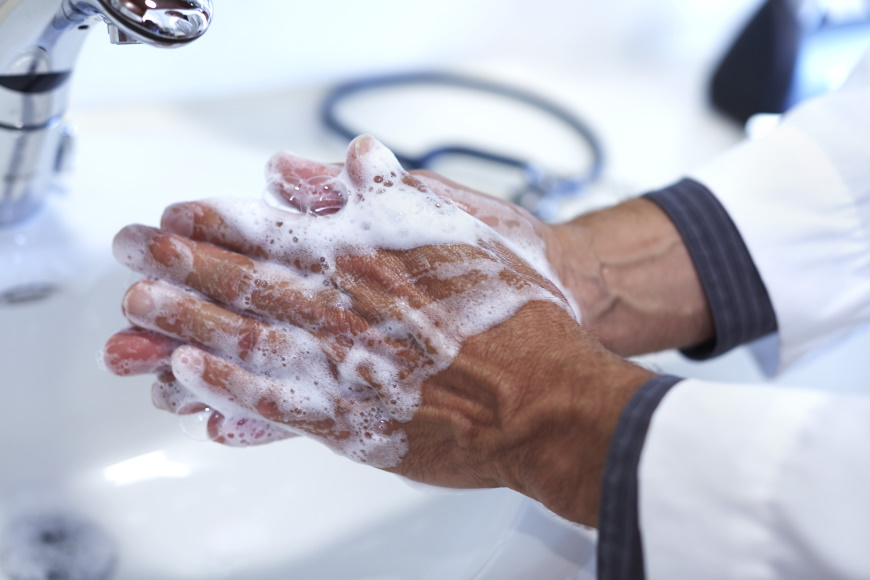Doctor washing hands into lather with hand sanitizer product