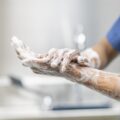 Healthcare worker washing hands with hand sanitizer