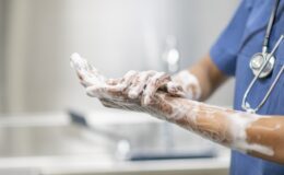 Healthcare worker washing hands with hand sanitizer